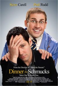 The poster for Dinner for Schmucks with Paul Rudd sitting with his hand on his head and Steve Carell grinning behind him with hands on Rudd's shoulders