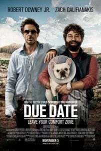 The poster for the movie Due Date with Robert Downey Jr. and Zach Galifianakis looking haggard with a desert road behind them while Galifianakis holds a white bulldog in a cone