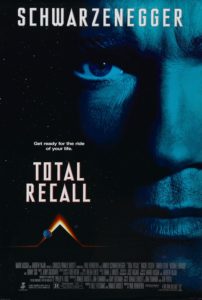 Total Recall movie poster with Arnold Schwarzenegger's face in blue with the title to the left.
