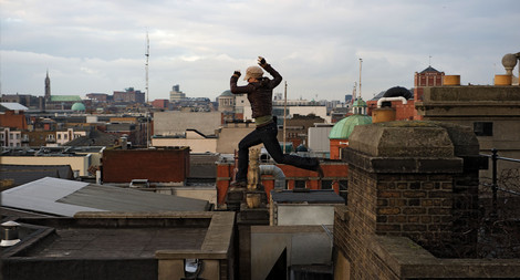 Gina Carano leaping across a rooftop in the movie Haywire