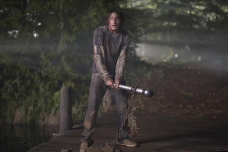 Fran Kranz stands bloodied while holding his coffee cup bong as a weapon in The Cabin in the Woods