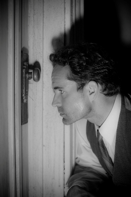 Jason Patric in Keyhole looking into a keyhole.