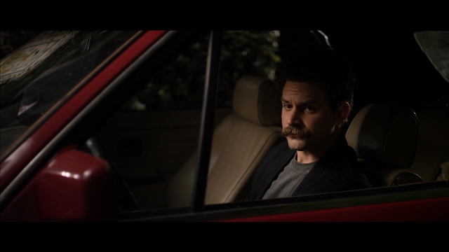 Alev Aydin in the film Lonely Boy sitting miserable in a car