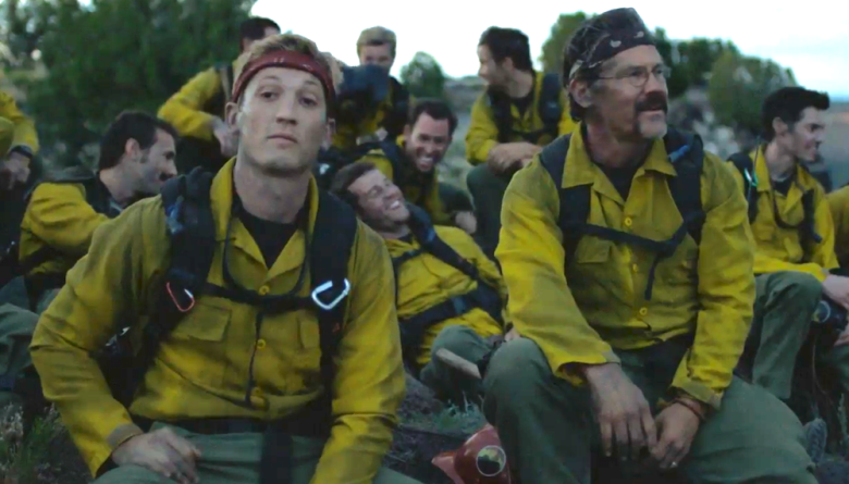 Miles Teller and Josh Brolin rest side by side in their firefighting equipment in Only the Brave.