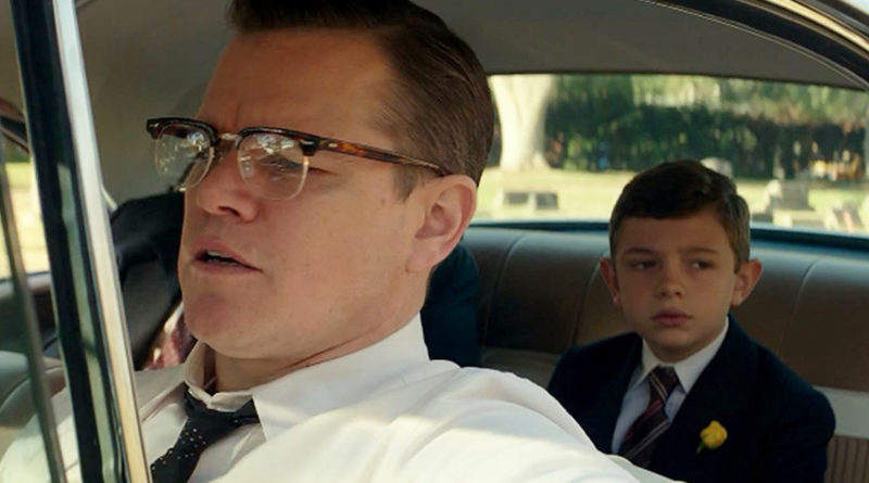 Matt Damon in Suburbicon driving a car while his kid in the movie rides in back.