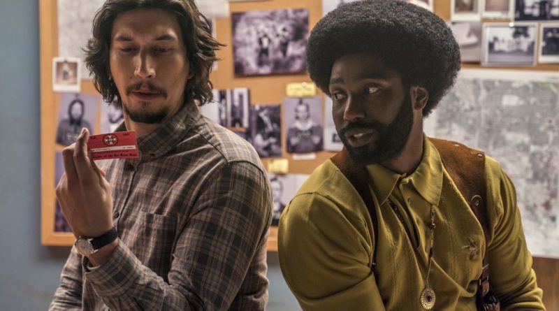 Adam Driver and John David Washington look at a KKK id card in BlacKkKlansman