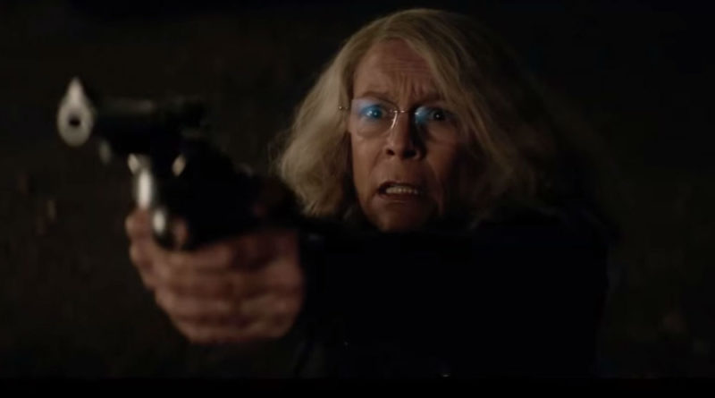 Jamie Lee Curtis looking worried pointing a revolver at the camera in the 2018 film Halloween