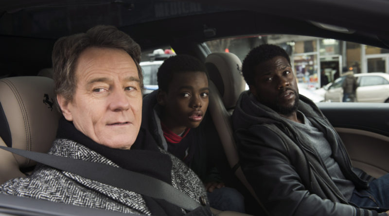 Bryan Cranston, Jahi Di'Allo Winston, and Kevin Hart look out the open window of a car's passenger side in the movie The Upside.