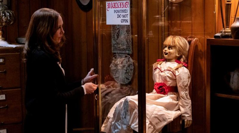 Vera Farmiga locks up Annabelle the doll in a glass cage in the horror movie ANNABELLE COMES HOME