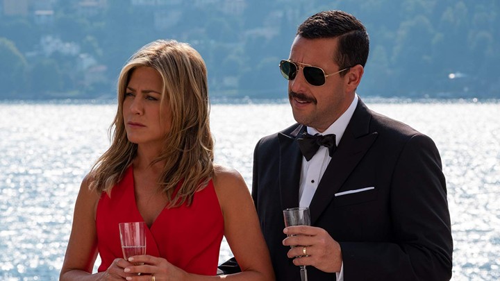 Jennifer Aniston and Adam Sandler raise a glass of champagne in the Netflix movie Murder Mystery