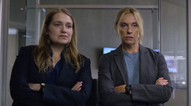 Merritt Wever and Toni Collette stand with their arms crossed looking at something in the Netflix series Unbelievable
