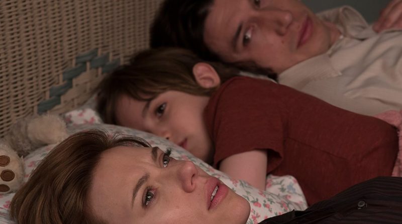 Scarlett Johansson and Adam Drive lay in bed with Azhy Robertson between them in the movie Marriage Story