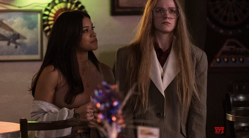 Gina Rodriguez looks longingly at Evan Rachel Wood, who stares ahead blankly in the movie Kajillionaire