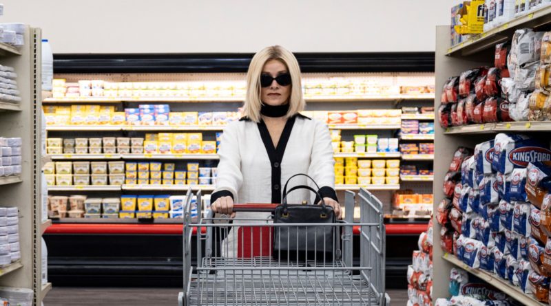 Barbara Crampton wearing sunglasses inside pushing a shopping cart at a grocery store in the horror movie Jakob’s Wife